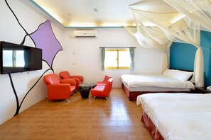 A hotel room with two beds, a TV, a seating area with red chairs, and a window with curtains. - Kenting Star Inn (Hengchun)