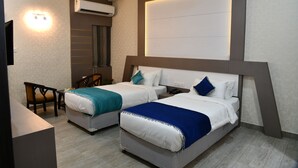 Habitación de hotel con dos camas, un escritorio y una silla.