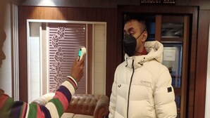 Una persona usando un dispositivo digital en una habitación con un letrero que dice "BANQUET HALL".