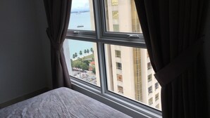 A hotel room with a large window, curtains, and a bed. - Mansion One Bedroom Suite (George Town)