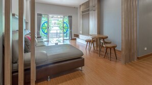 Ein modernes Wohnzimmer mit einer Couch, einem Esstisch mit Hocker und Blick durch große Fenster.
