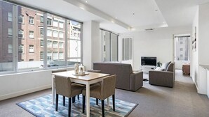 Um apartamento moderno com área de jantar, sala de estar e televisão.