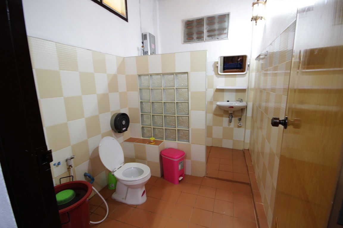 A small bathroom with a toilet, sink, and a window with a view of the outside.