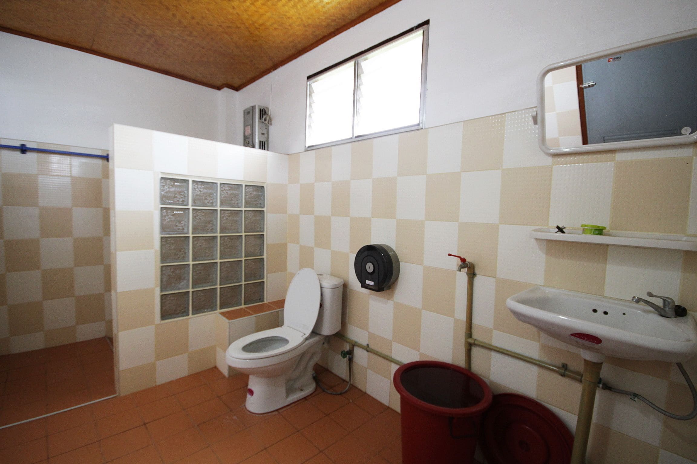 A small bathroom with a toilet, a sink, and a window.