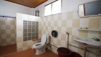A small bathroom with a toilet, a sink, and a window.