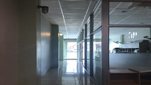 A corridor with a tiled floor, glass doors, and a ceiling with recessed lighting. - Eve Place Pattaya (Pattaya)