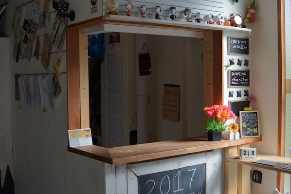A reception desk with a chalkboard displaying the year 2017, surrounded by various papers and notices.