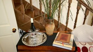 A wooden side table with a tray, a vase with plants, and a book. - Annies Garden Cottage (South Hobart)