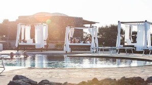 Uma área de piscina com espreguiçadeiras e um gazebo.