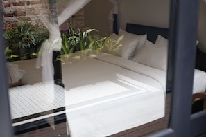 A bed with white bedding, a headboard, and a window with a view of plants. - Tian Jing Hotel (Kuala Lumpur)
