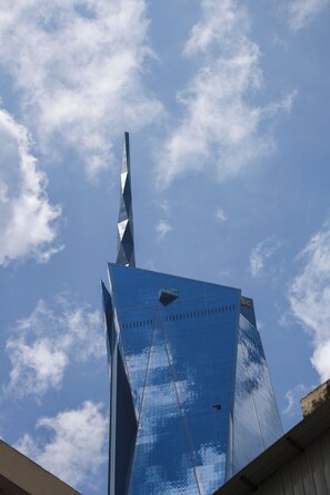 A tall, modern building with a distinctive spire and reflective glass facade. - Tian Jing Hotel (Kuala Lumpur)