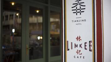 A hotel entrance with the name "TIANJING HOTEL" and "LIMKEE CAFE" visible on the wall.
