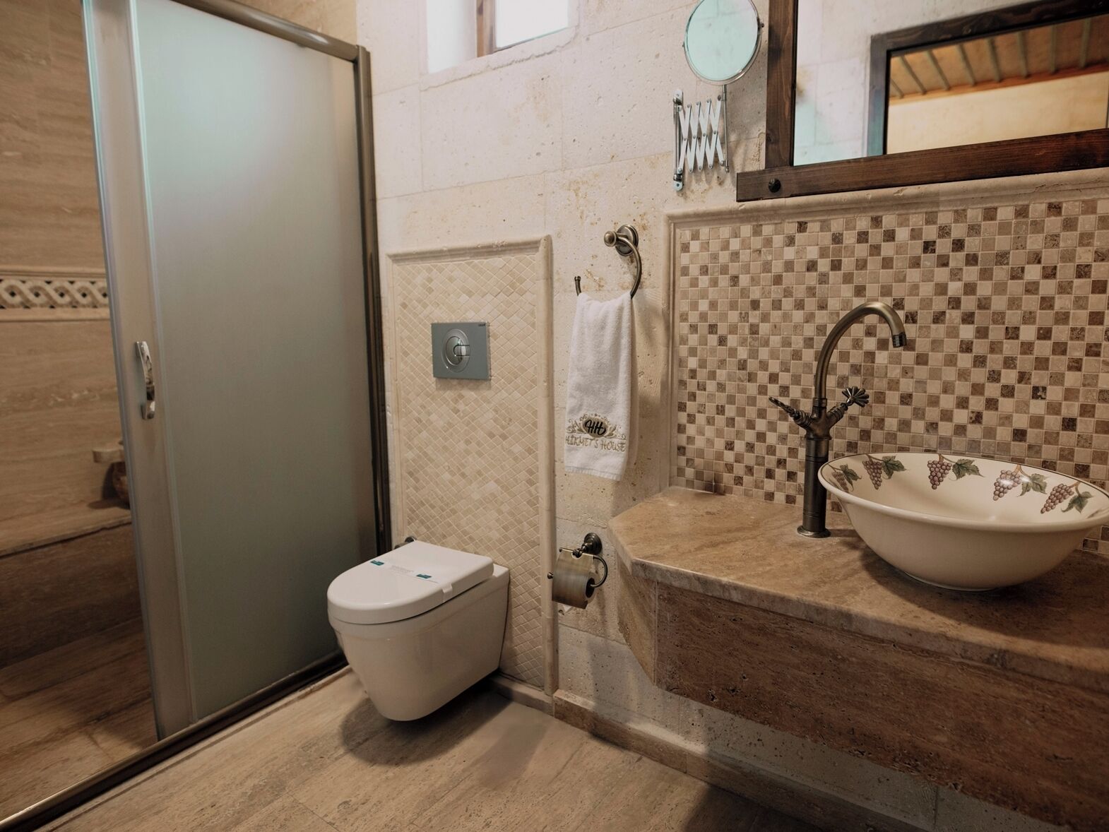 A bathroom with a toilet, a sink with a checkered backsplash, and a mirror above the sink.