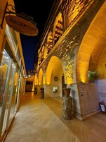 A reception area with a sign, stone arches, and potted plants.