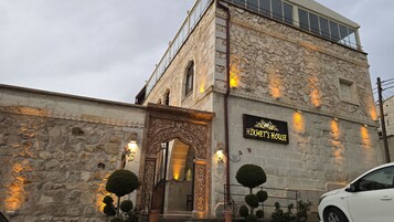 A stone building with a sign reading "HIKMET'S HOUSE" and a balcony.