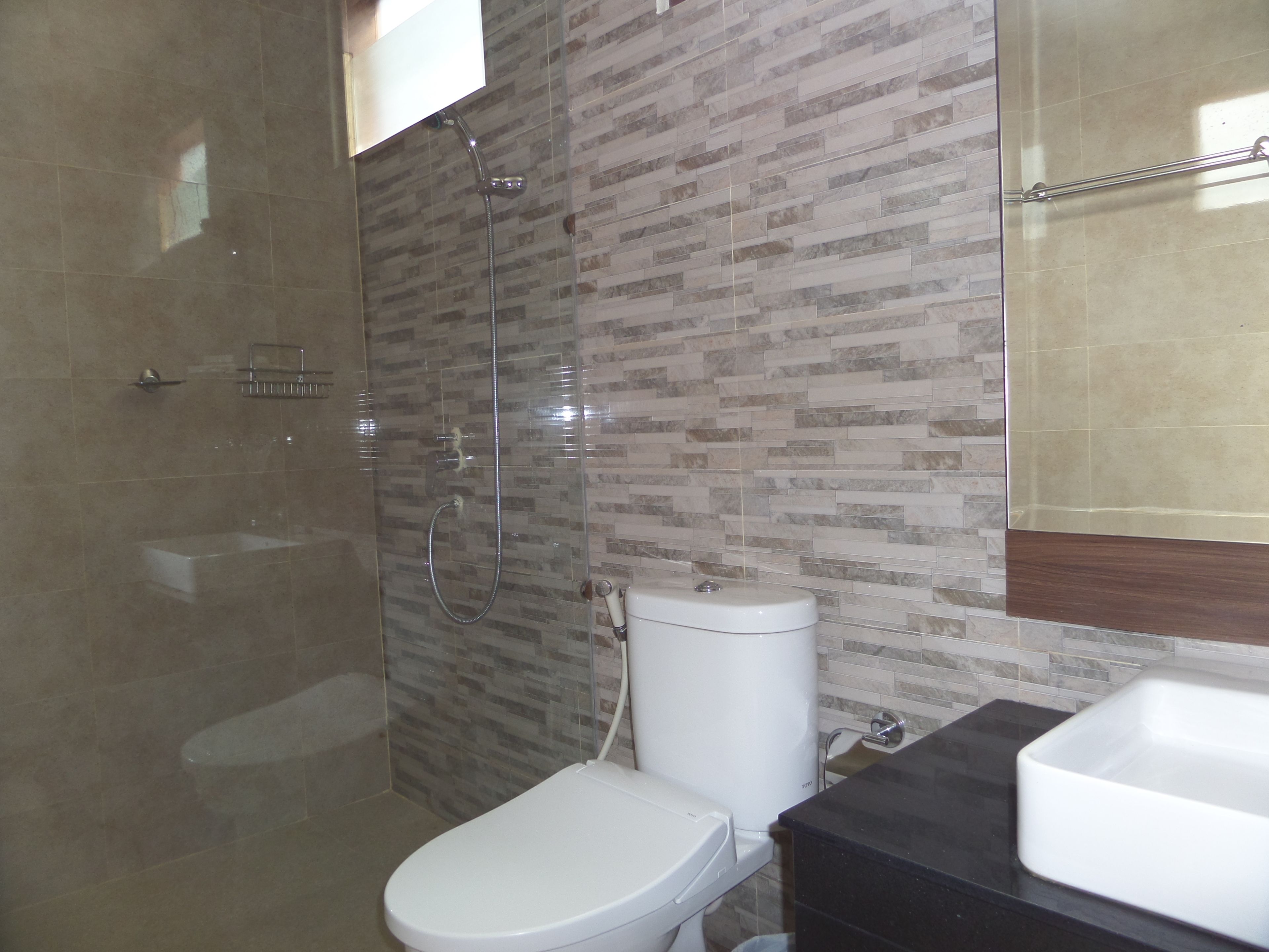 A bathroom with a shower, toilet, and sink.