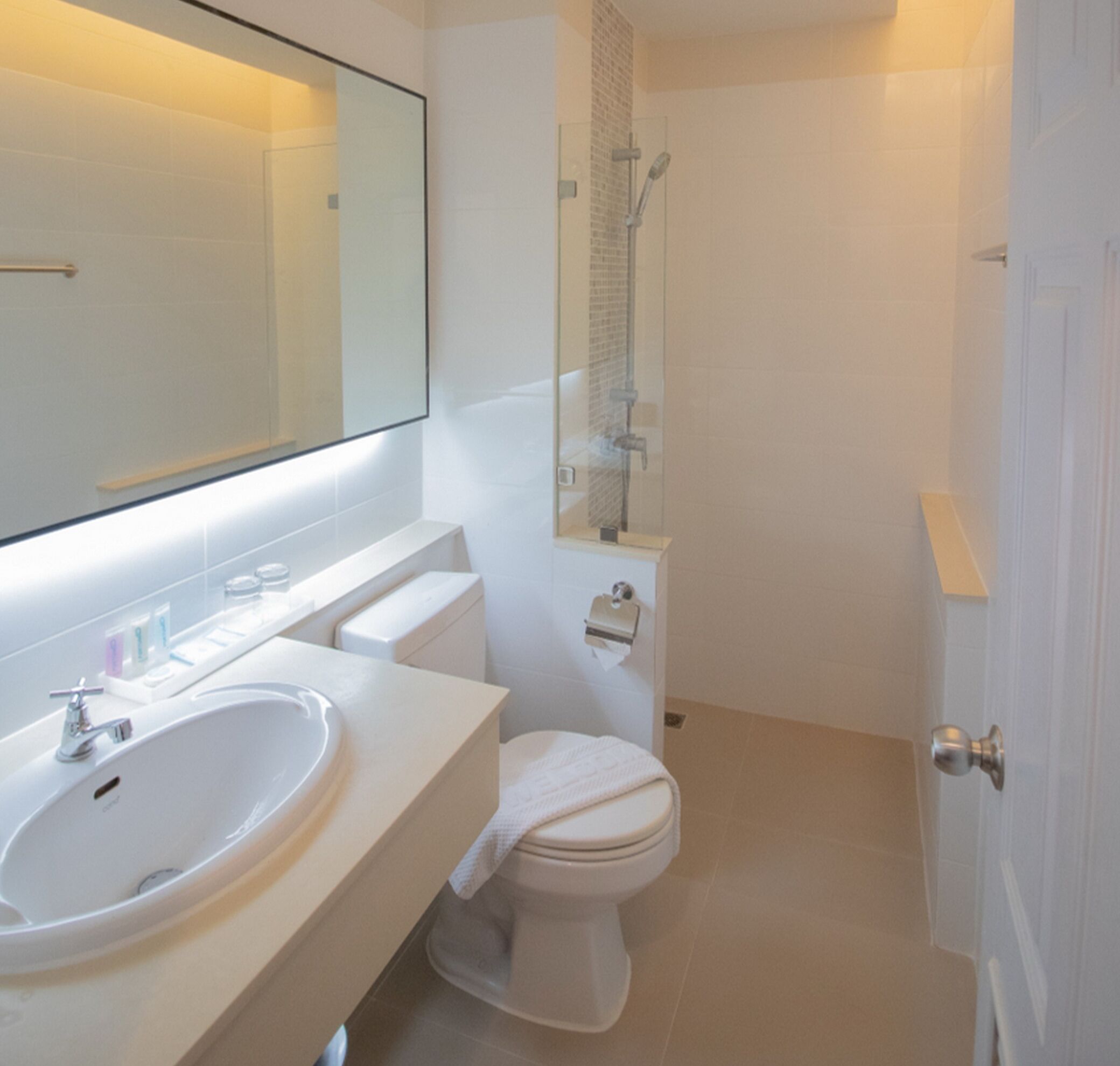 A modern bathroom with a white sink, toilet, and shower.