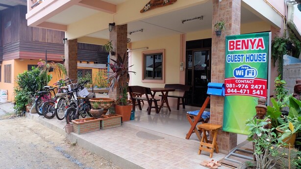 A guest house with a tiled patio, bicycles, and potted plants. - Benya Guest House Phimai (Phimai)