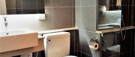 Un baño moderno con inodoro, lavabo y ducha.