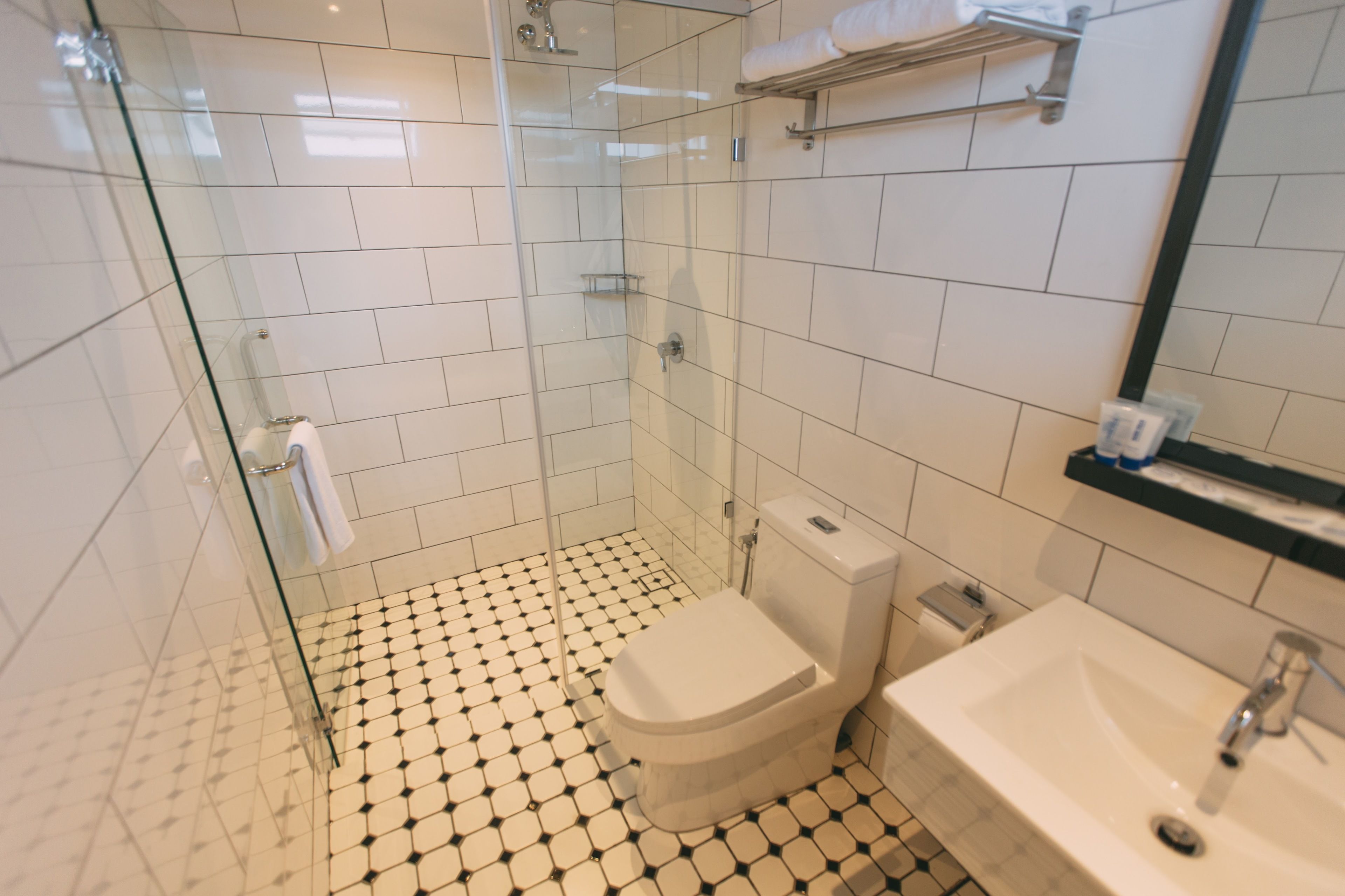 Un baño con ducha de vidrio, inodoro y lavamanos.