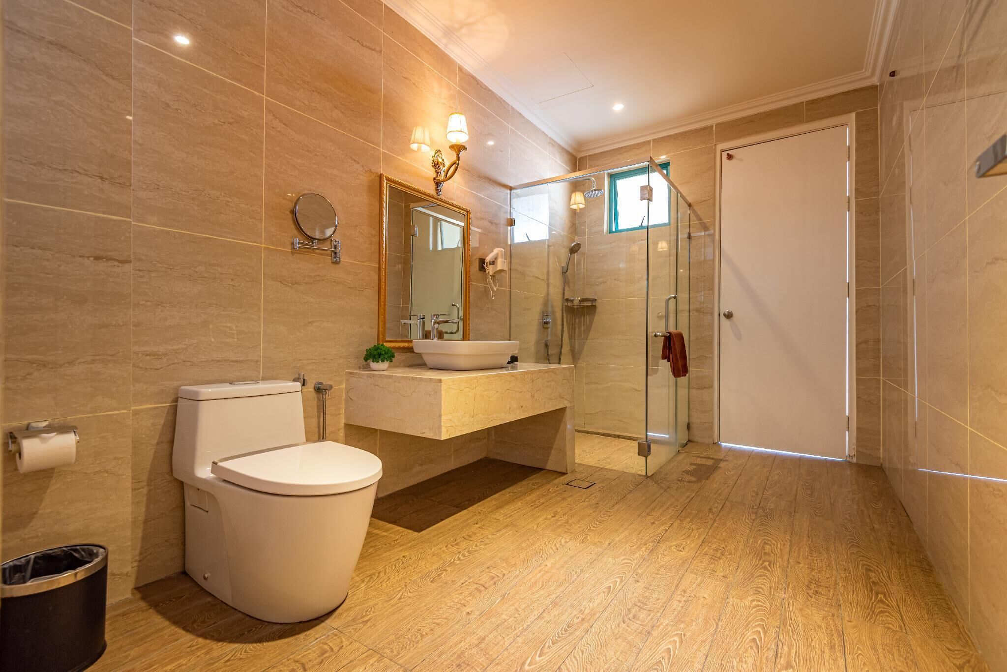 A modern bathroom with a toilet, sink, and glass-enclosed shower.
