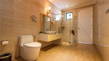 A modern bathroom with a toilet, sink, and glass-enclosed shower.