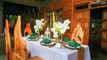 A dining table set with white flowers, green napkins, and a lantern.