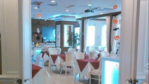 L’entrée d’un restaurant, avec des tables et des chaises, une enseigne indiquant « Hale ku lani Restaurant » et un paillasson portant le nom du restaurant.