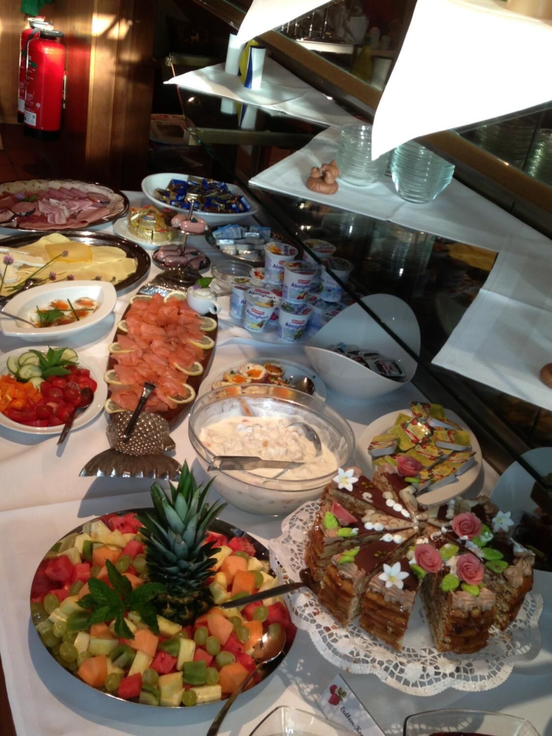 A buffet with various food items including fruits, salads, and desserts.