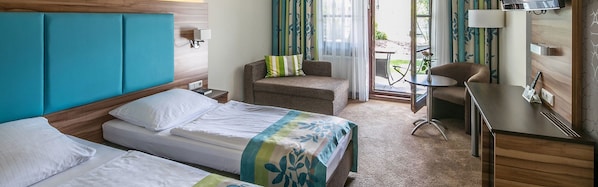 A hotel room with two beds, a desk, and a chair. - Hotel am Krone Park (Olching)