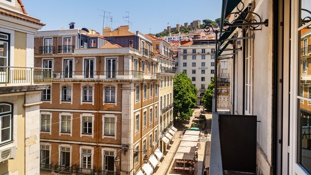 Una calle estrecha flanqueada por edificios, con balcones y una vista despejada.