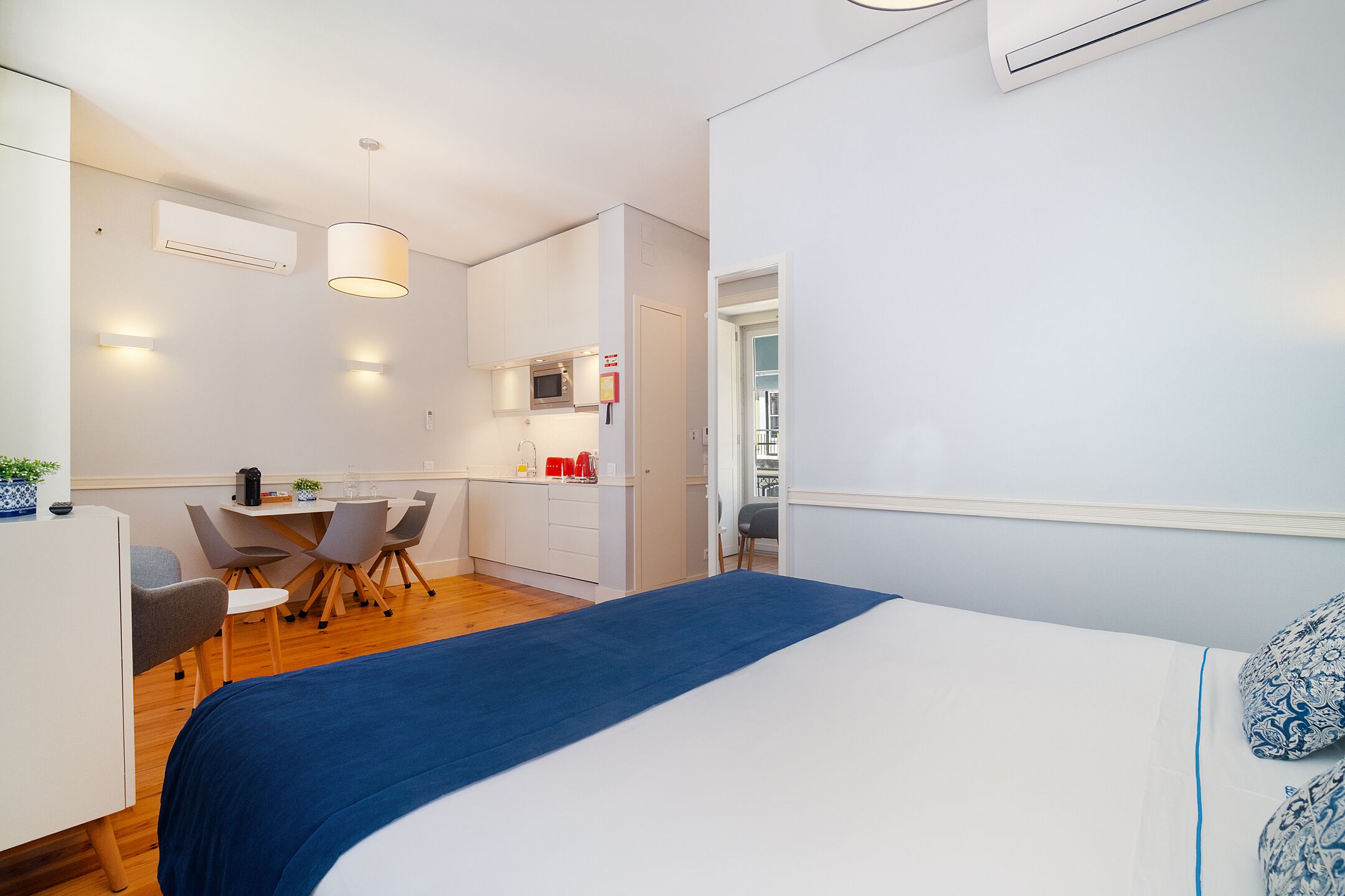 Et moderne hotelværelse med seng, skrivebord og tekøkken.