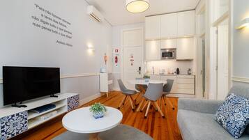 A modern living room with a flat-screen TV, a coffee table, and a sofa.