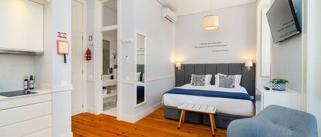 Una habitación de hotel moderna con cama, mesitas de noche, escritorio y una silla.