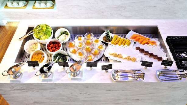 A buffet with various food items and utensils.