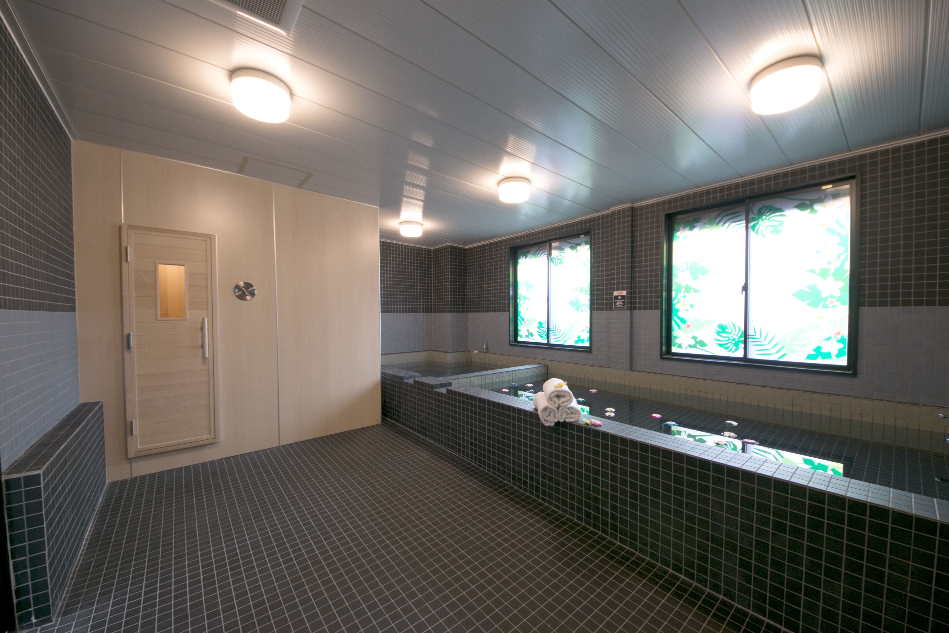 A modern bathroom with a large sink, a mirror, and a towel rack.