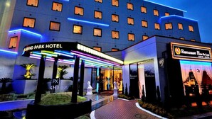A hotel with a modern facade, multiple floors, and illuminated signage.