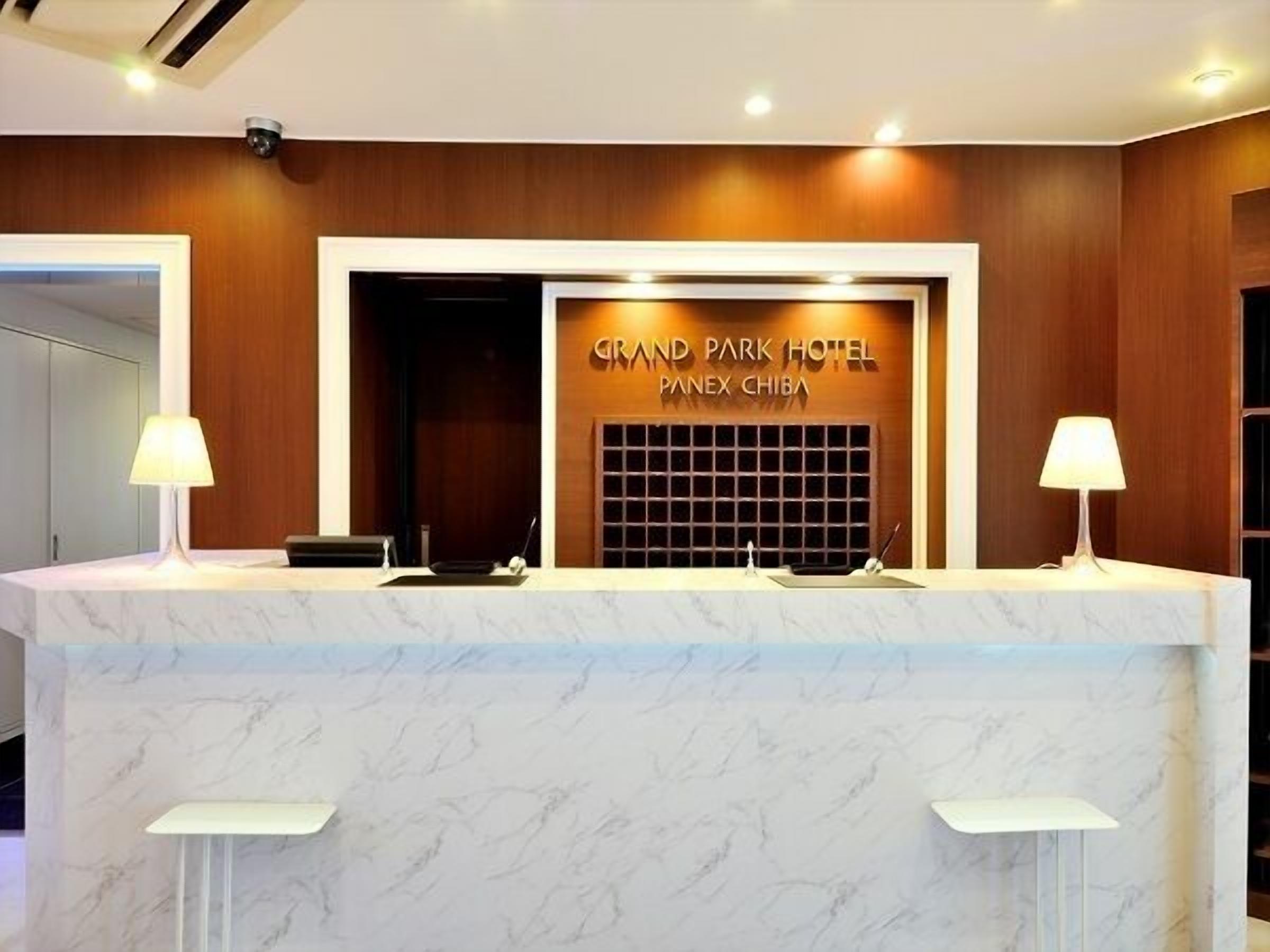 Bancada de recepção do Grand Park Hotel, com tampo de mármore e duas luminárias.