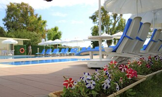 Una piscina al aire libre, sillones reclinables de piscina