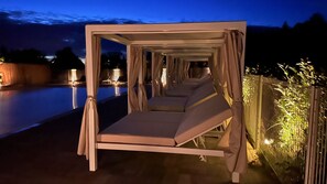 A series of outdoor beds with curtains, a pool, and a night sky. - Domaine Blue Garden (Grandvillers)