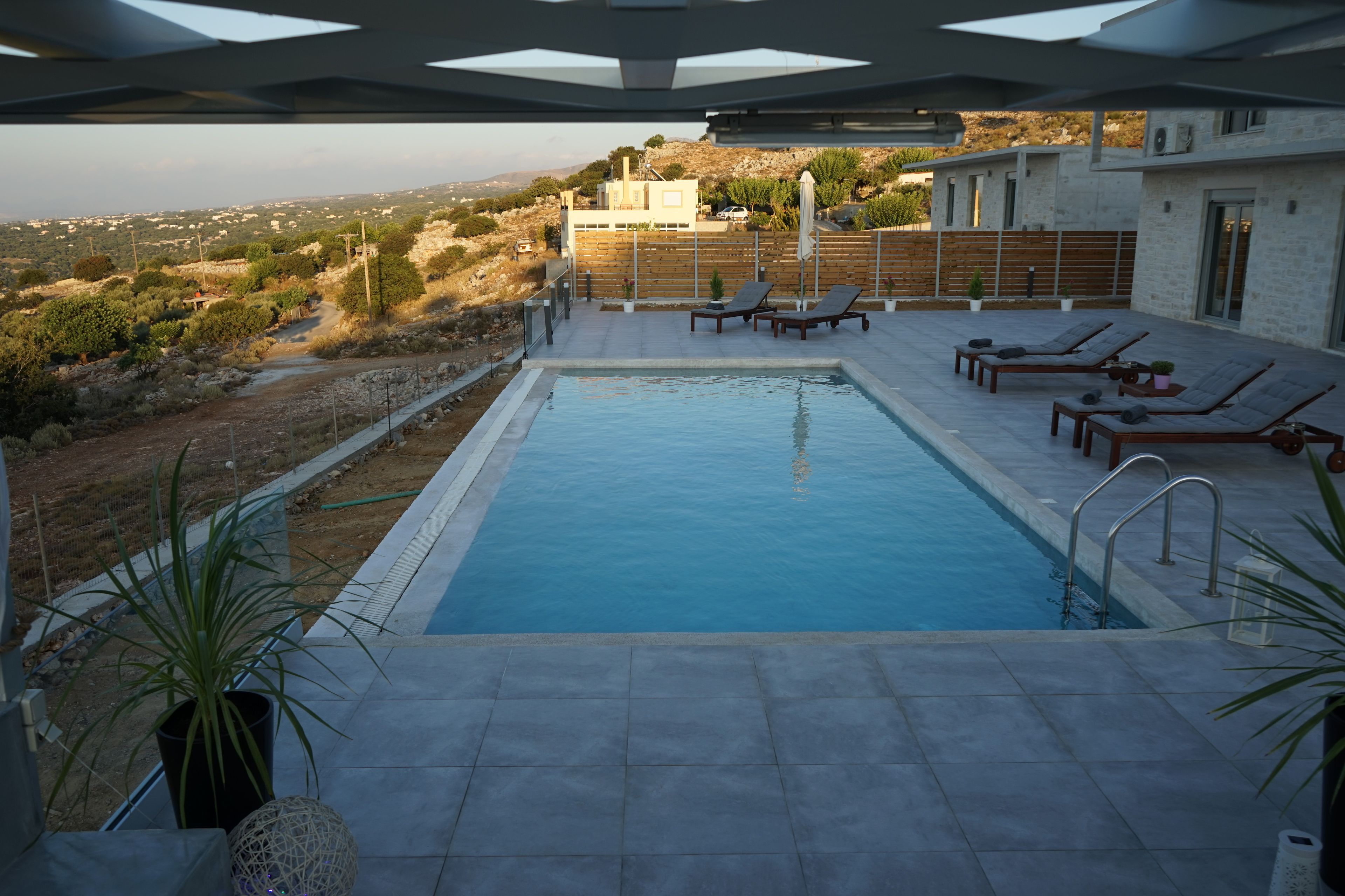 A swimming pool with lounge chairs and a view of the surrounding landscape.