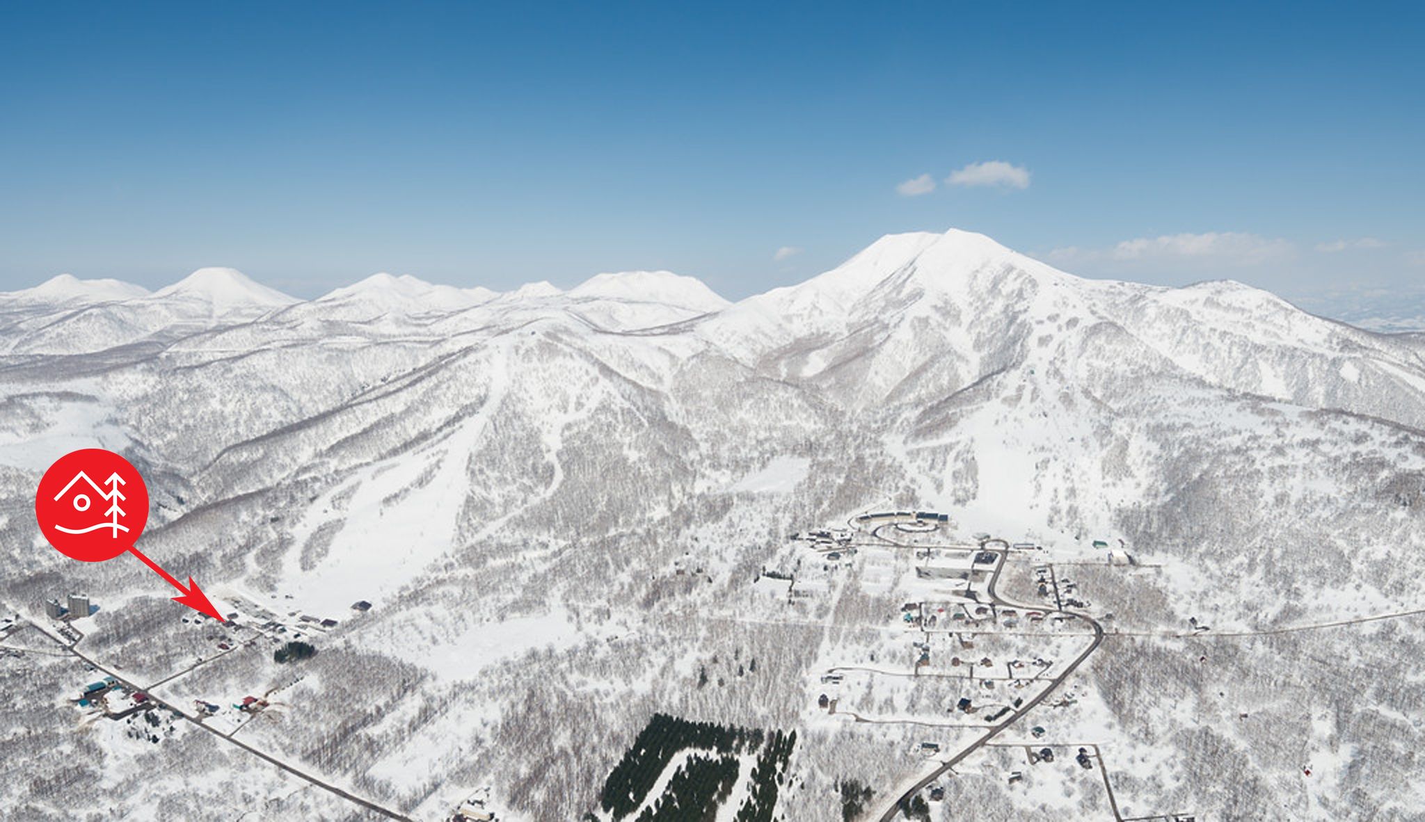 A snow-covered mountain landscape with a small town and a ski resort.