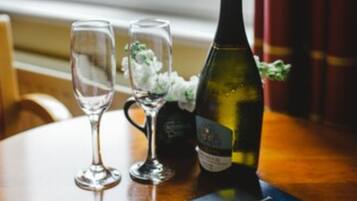A table with two wine glasses, a bottle of wine, and a menu.