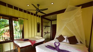 A bedroom with a bed under a canopy, a ceiling fan, and a window with curtains. - Tha Khao Bay View (Ko Yao)