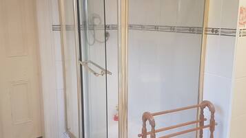 A glass-enclosed shower area with a wooden towel rack.