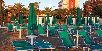 Playa privada, arena blanca, sillas reclinables de playa, sombrillas