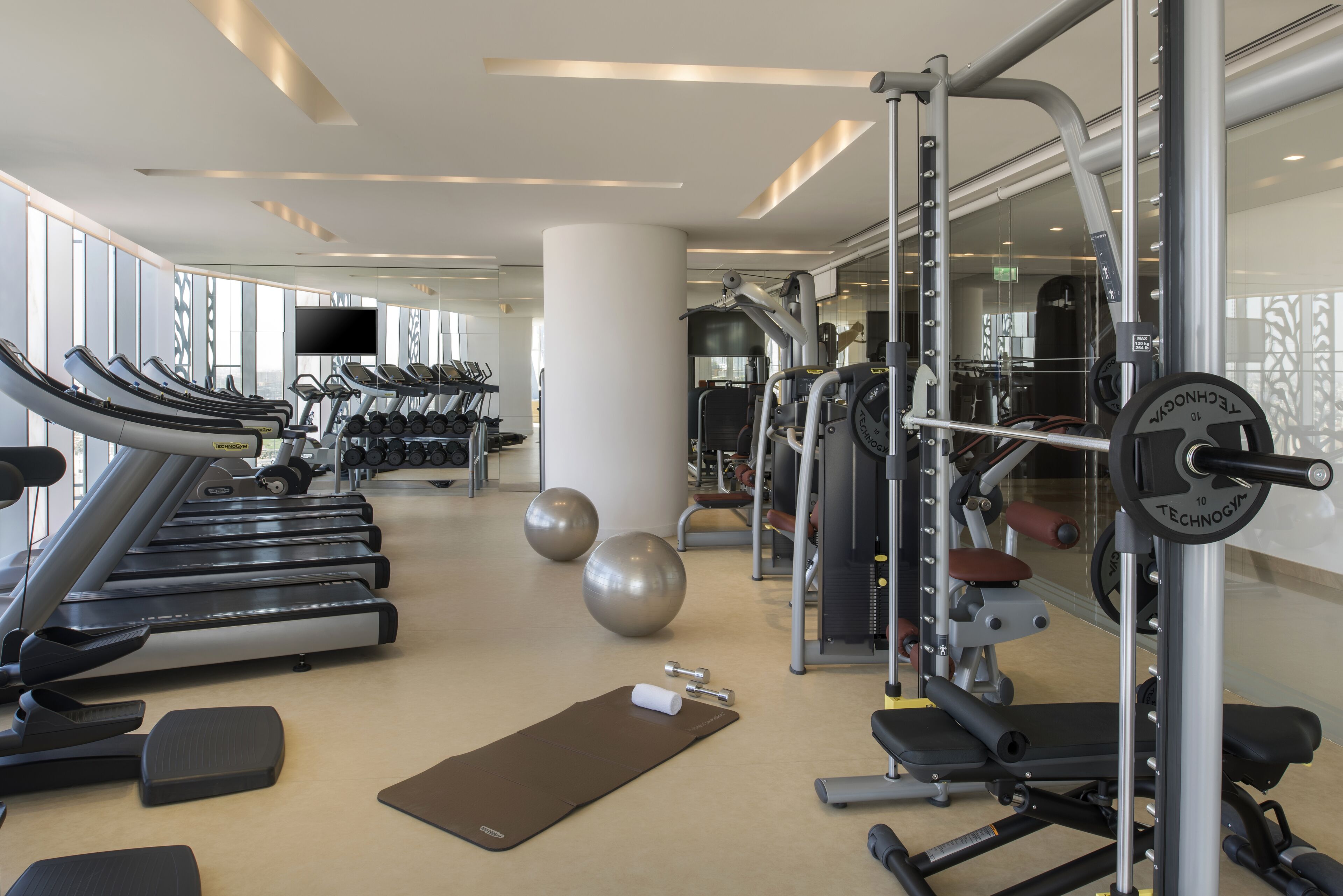 A gym with treadmills, exercise balls, and weightlifting equipment.