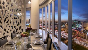 Ein Essbereich mit Blick auf die Stadt, moderne Einrichtung und ein gedeckter Tisch.