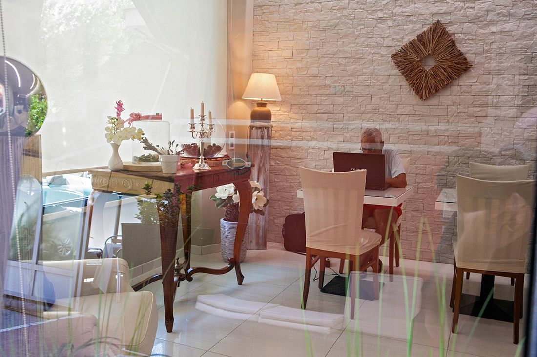A dining area with a stone wall, a table with candles, and a lamp.
