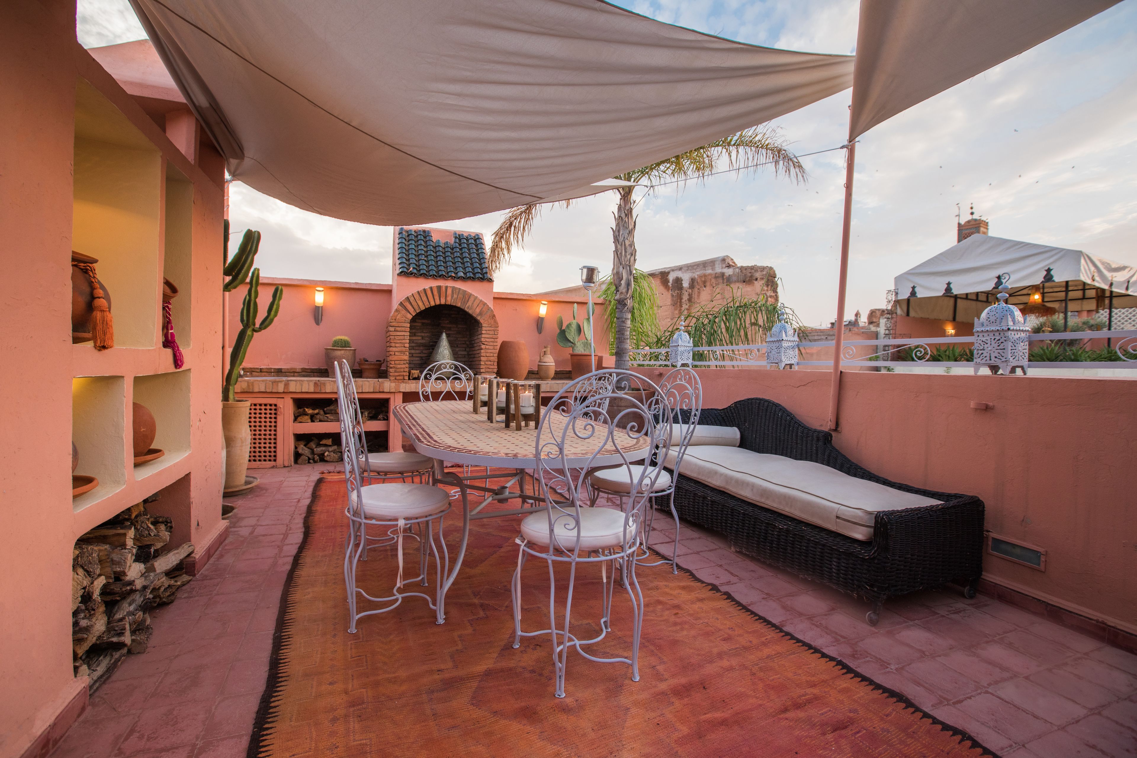 Un patio al aire libre con una mesa y sillas, un sofá y una pared decorativa.